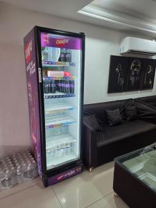 a refrigerator with drinks in it next to a couch at Vrind Orchid- Near Prem Mandir in Vrindāvan
