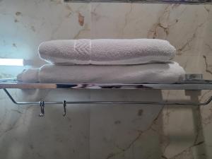 a stack of towels on a shelf in a bathroom at Vrind Orchid- Near Prem Mandir in Vrindāvan