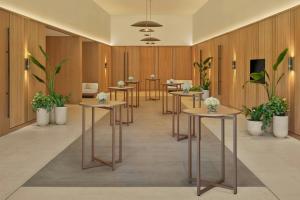 a row of tables in a room with plants at The Red Sea EDITION in Ḩanak +56 photos