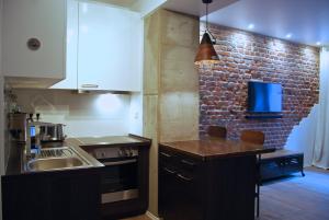 a kitchen with a sink and a brick wall at Jordan Suite Executive Furnished Apartment in Düsseldorf