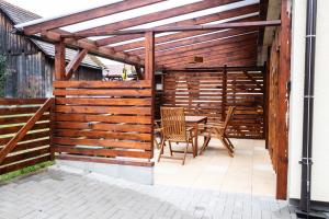 a wooden pergola with a table and chairs on a patio at Apartmán Malá Valaška in Ratiboř +56 photos