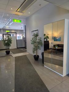 an office with two potted trees in a lobby at Hotell Centralstation in Uppsala