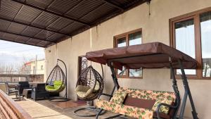 a porch with two chairs and a patio umbrella at Syunyats guest house in Halidzor