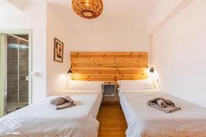 two beds in a bedroom with a wooden headboard at AtuaireHome Hostal en el centro de Burgos in Burgos