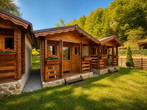 a group of wooden cottages in a yard at Căbănuțe Izbândiș in Şuncuiuş