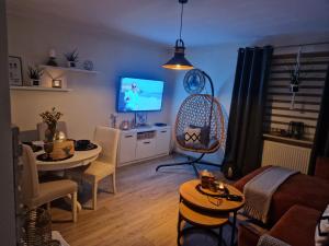 a living room with a table and a tv in it at PIK-KWATERY in Olsztyn