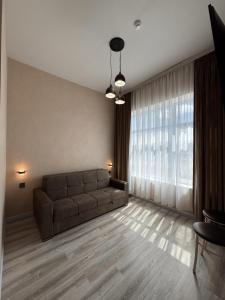 a living room with a couch and a large window at Miva in Qusar
