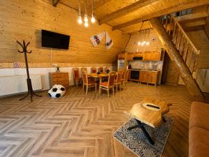 a living room with a table and a soccer ball on the floor at Căbănuțe Izbândiș in Şuncuiuş