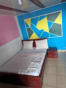 a bed in a room with a painting on the wall at BALI HOTEl in Yaoundé +3 photos