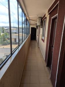 an empty hallway of a building with windows and a hallwayngth at BALI HOTEl in Yaoundé