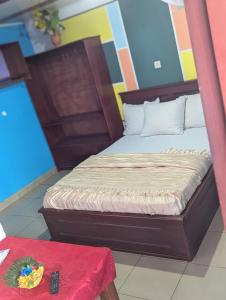 a bed in a room with a red table at BALI HOTEl in Yaoundé