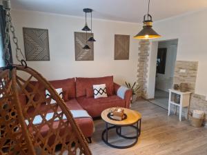 a living room with a red couch and a table at PIK-KWATERY in Olsztyn
