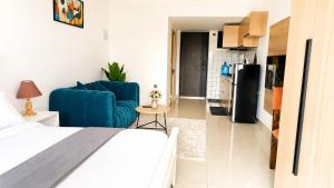 a bedroom with a bed and a blue chair and a kitchen at Casa Liora Studio by UN & Two Rivers in Nairobi +21 photos