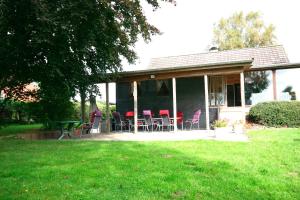 a house with chairs and a table in a yard at Ferienhaus Schlei in Rabenkirchen-Faulück