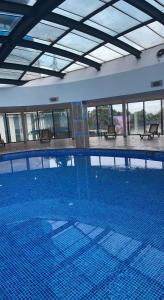 a large swimming pool in a building with a ceiling at Batumi Best View in Batumi