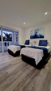 a bedroom with three beds and a large window at Strode House in Knysna +34 photos