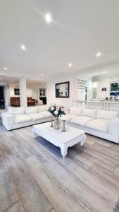 a large living room with white couches and a table at Strode House in Knysna