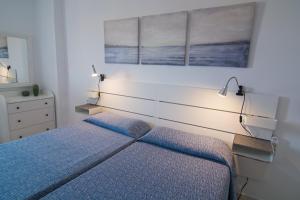 a bedroom with a bed with blue sheets and lights at Torres del Sol - Los Cristianos in Los Cristianos +68 photos