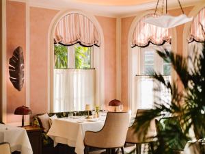 a dining room with a table and two windows at The Vineta Hotel, Oetker Hotels in Palm Beach