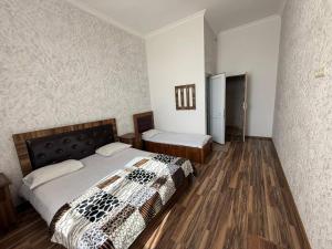 a bedroom with a large bed and wooden floors at Mirage in Shinuhayr