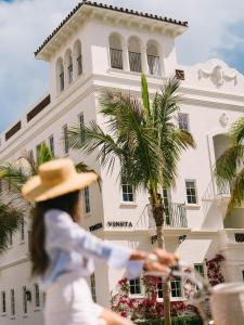 a woman riding a bike in front of a building at The Vineta Hotel, Oetker Hotels in Palm Beach
