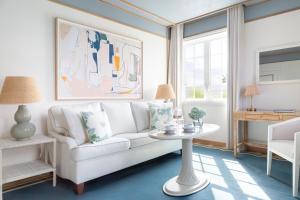 a living room with a white couch and a table at The Vineta Hotel, Oetker Hotels in Palm Beach