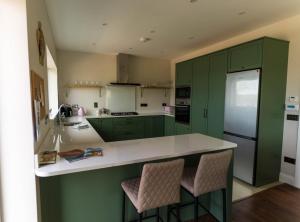 a kitchen with green cabinets and a white counter top at Renard Haven - Cahersiveen in Cahersiveen