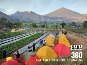 a group of people standing in a field with tents at Sada 360 Nanu Homestay in Sembalun Lawang