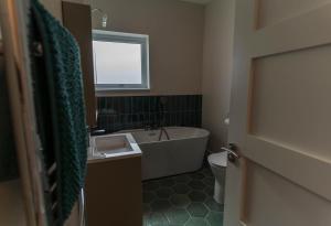 a bathroom with a tub and a sink and a toilet at Renard Haven - Cahersiveen in Cahersiveen +13 photos