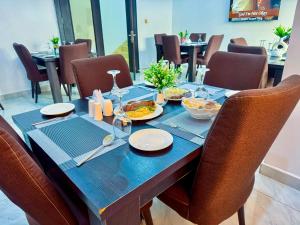 a blue table with plates of food on it at Diplomats Enclave Suites in Jikoyi