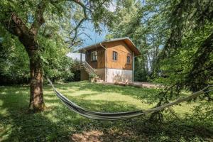 a hammock in front of a house in a yard at Campement Ô Rêves in Genouilleux