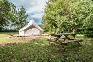a tent and a picnic table in a field at Campement Ô Rêves in Genouilleux