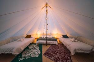 a room with three beds in a tent at Campement Ô Rêves in Genouilleux