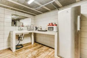 a small kitchen with a refrigerator and a sink at Campement Ô Rêves in Genouilleux