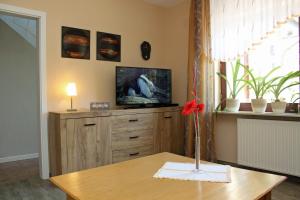 a living room with a tv on top of a dresser at Haus Hahn in Suhlendorf