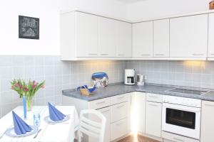 a kitchen with white cabinets and a table with chairs at Haus Hahn in Suhlendorf