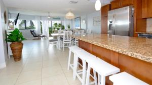 a kitchen with white stools and a counter top at 305 Kawama Tower in Key Largo