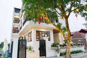 a house with a tree in front of it at Tam Cốc Hà Anh Hotel in Văn Lâm