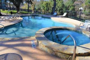 a large swimming pool with a spa in a yard at Treasure on Comal! in New Braunfels