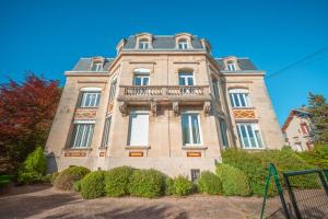 a large stone building with a balcony at Le Grand Rivage in Verdun-sur-Meuse