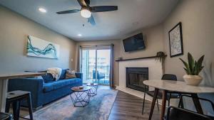 a living room with a blue couch and a fireplace at Treasure on Comal! in New Braunfels