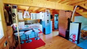 a kitchen with a refrigerator and stools in a room at Vila Vilinka & Vila Native Vilinija resort Village in Podčetrtek