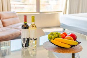two bottles of wine and a bowl of fruit on a table at Hotel Casa Nogales in Santiago +20 photos
