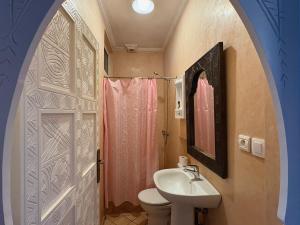 a bathroom with a sink and a toilet and a door at Appartement terrasse de la mer in Mirleft +36 photos