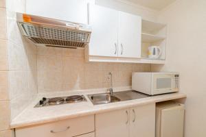 a small kitchen with a sink and a microwave at Hotel Casa Nogales in Santiago