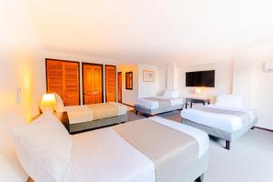 a hotel room with two beds and a television at Hotel Casa Nogales in Santiago