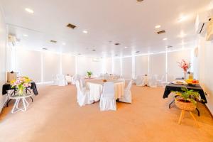 a banquet hall with white tables and white chairs at Hotel Casa Nogales in Santiago