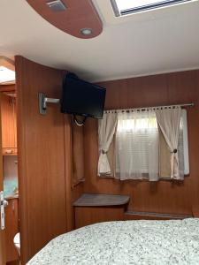 a bedroom with a bed and a flat screen tv at Camping car Paris in Savigny-le-Temple