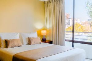 a bedroom with a bed and a large window at Hotel Casa Nogales in Santiago