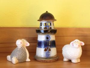 two figurines of animals sitting next to a lighthouse at Ferienwohnung Heuer in Ebstorf